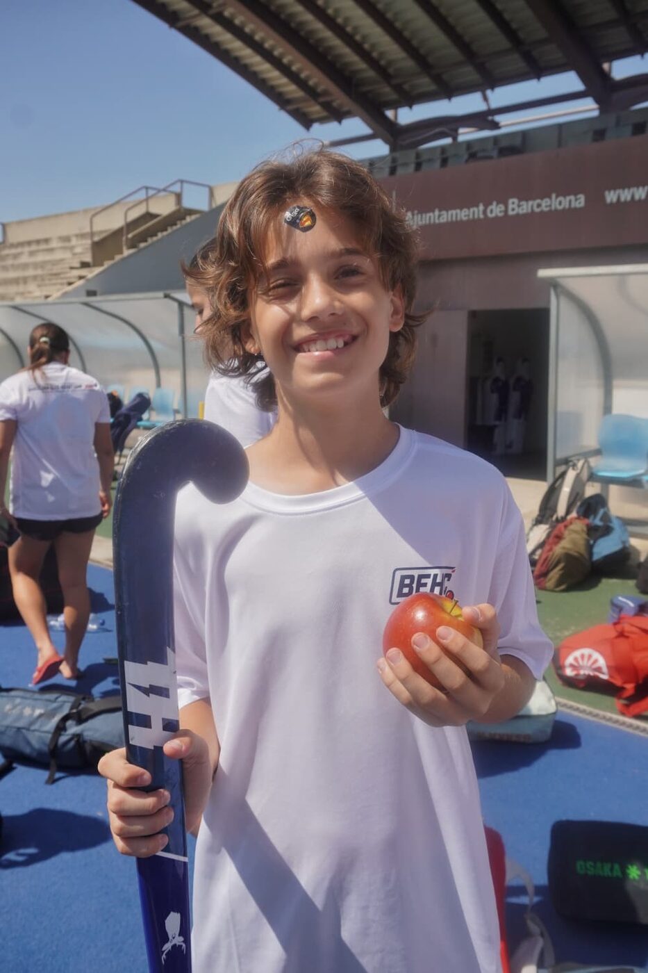 Jugador sonriendo con su stick y una manzana