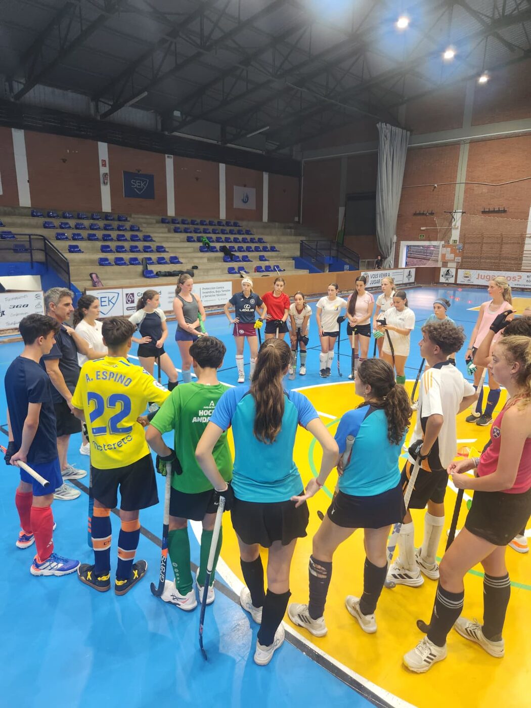 Entrenador dando indicaciones al grupo en el pabellón de hockey sala