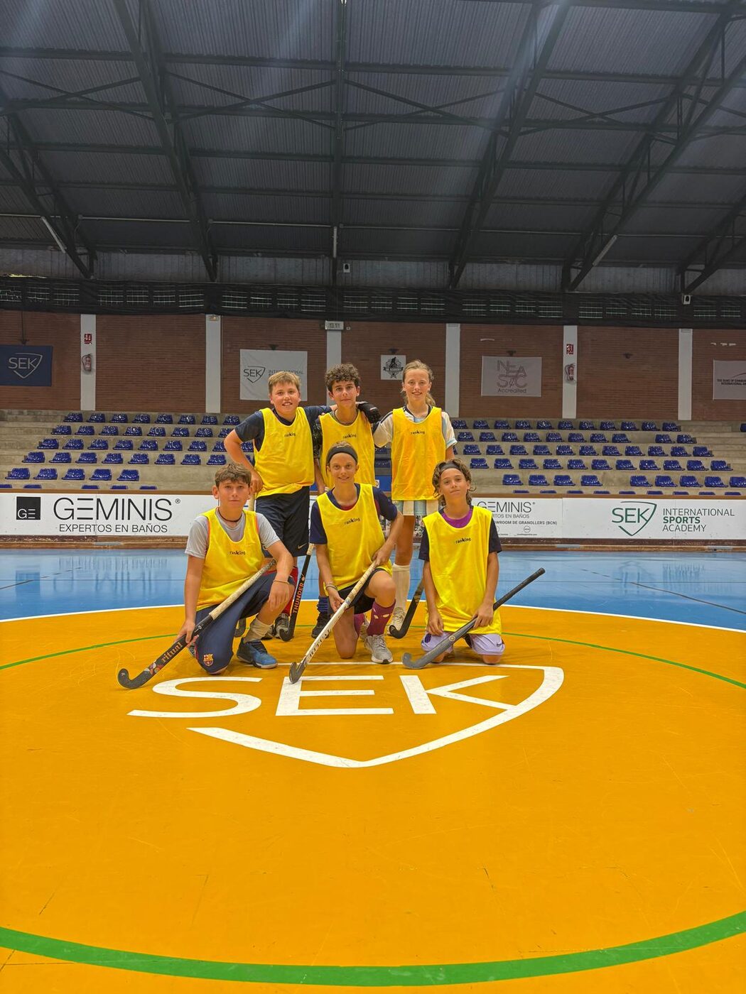 Equipo posando en el círculo central del pabellón SEK
